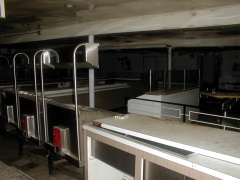 Behind the serving counter, and the restrooms can be seen on the back wall. An 8-track tape is on the counter.