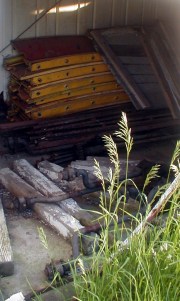 Parts of a carousel stored in the white storage shed.
