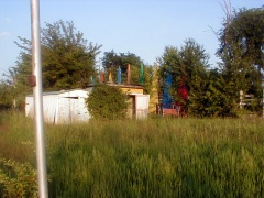 Photo of the playground area and a white storage shed.