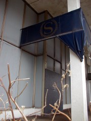 sheraton7large Front door of the hotel boarded over with grey plywood. Note the fake painted door handles.