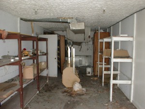 The storage room from a missing door on the east side. Door on left opens behind the serving counter, door on right (not shown) opens into house.